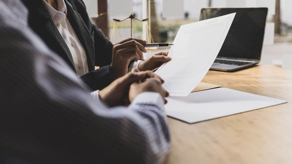 two business people sitting at a desk looking at a piece of paper